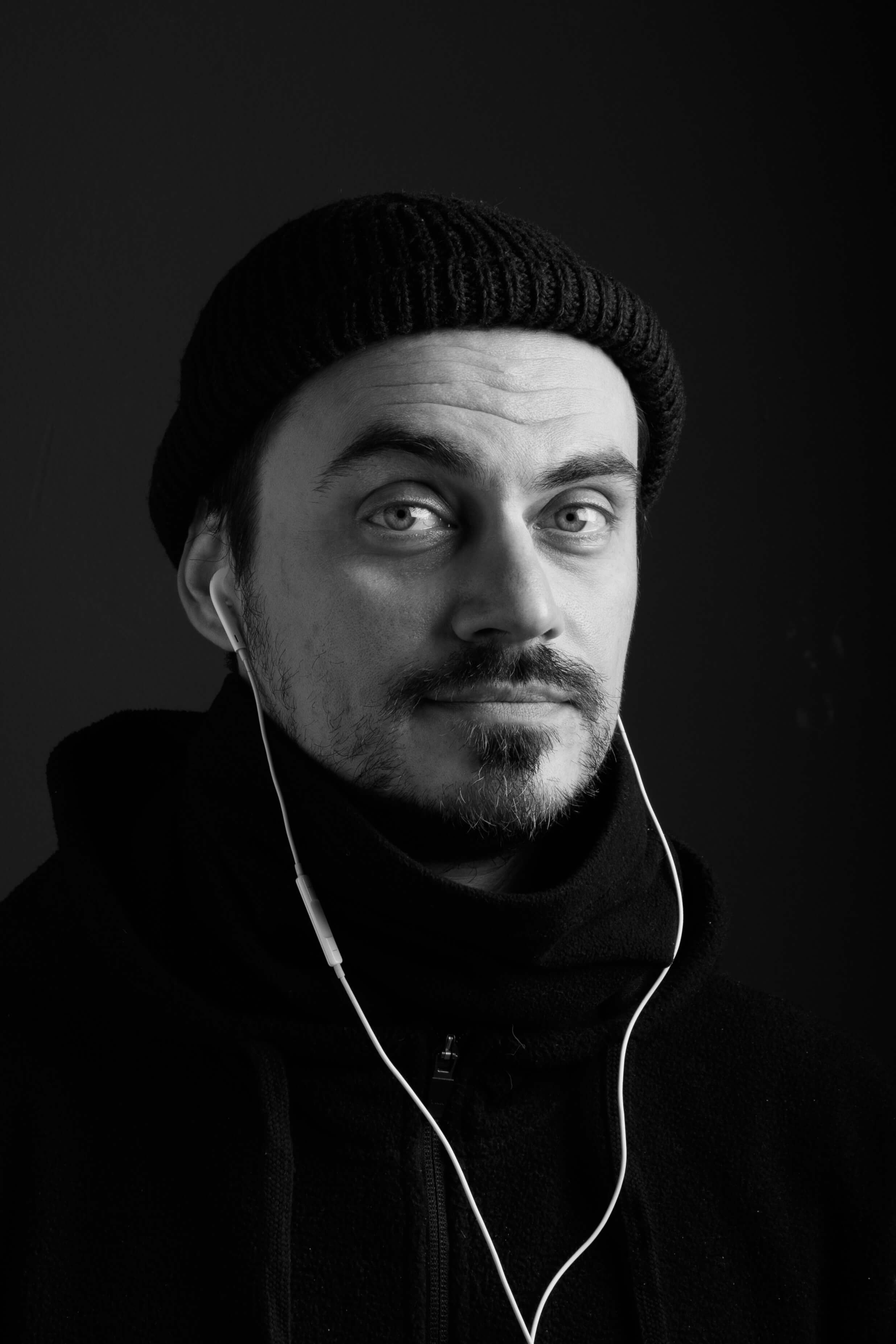 Dimitar Inchev looking surprised wearing a black winter hat and headphones.